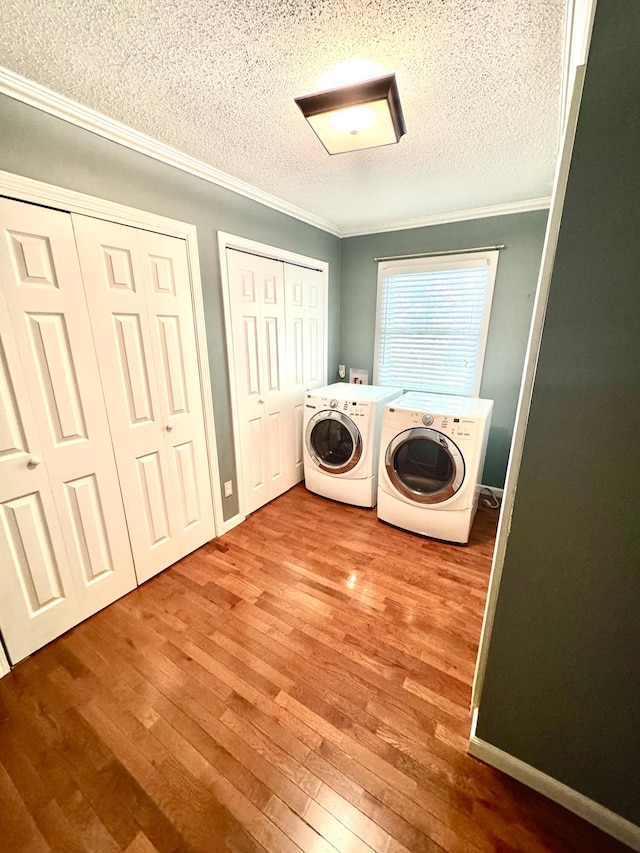 laundry area with independent washer and dryer, crown molding, a textured ceiling, and hardwood / wood-style floors