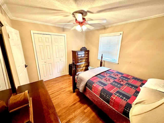 bedroom featuring ceiling fan, crown molding, light hardwood / wood-style flooring, a textured ceiling, and a closet