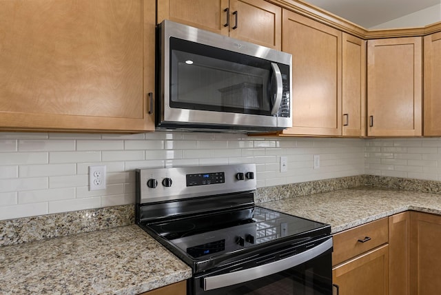 kitchen featuring range with electric cooktop, stainless steel microwave, light stone countertops, and tasteful backsplash