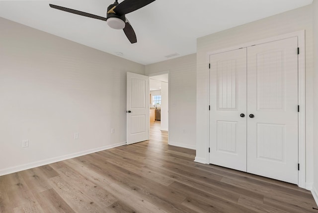 unfurnished bedroom with a closet, baseboards, and wood finished floors