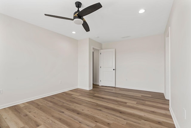 unfurnished room with recessed lighting, wood finished floors, a ceiling fan, and baseboards