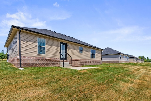 view of front of home featuring entry steps and a front lawn