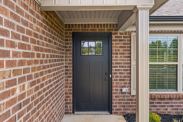 doorway to property featuring brick siding