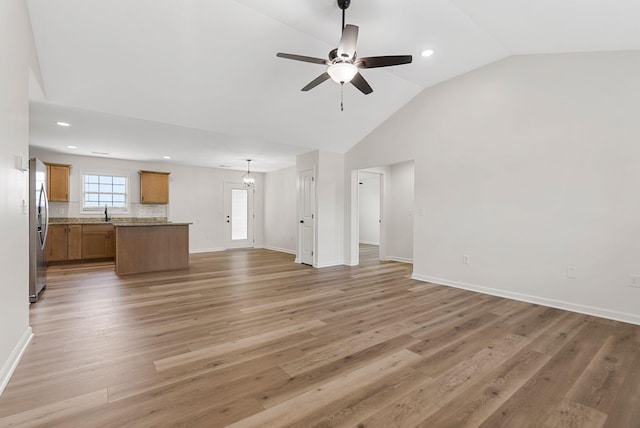 unfurnished living room featuring baseboards, ceiling fan, recessed lighting, and light wood-style floors