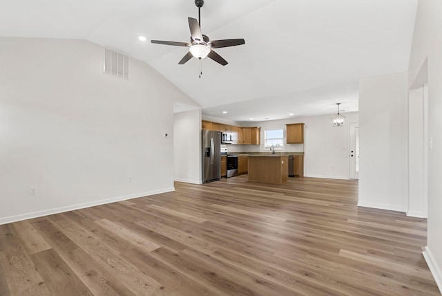 unfurnished living room featuring ceiling fan with notable chandelier, baseboards, visible vents, and light wood-style floors