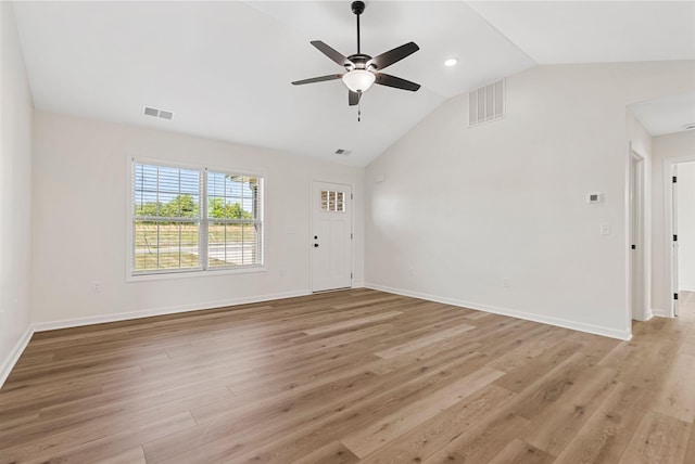 spare room with vaulted ceiling, light wood-type flooring, and visible vents