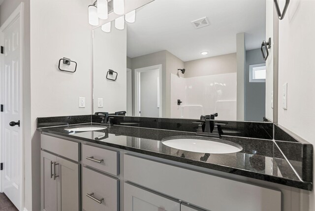 bathroom featuring a shower and vanity