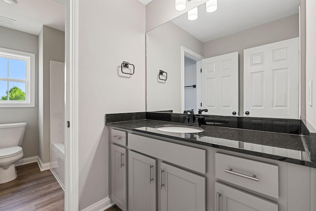 bathroom with hardwood / wood-style floors, vanity, and toilet