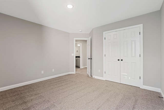 unfurnished bedroom with light carpet and a closet