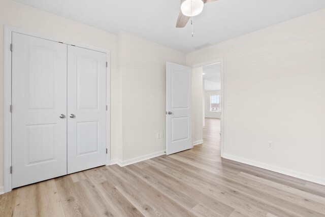 unfurnished bedroom featuring ceiling fan, light wood-type flooring, and a closet