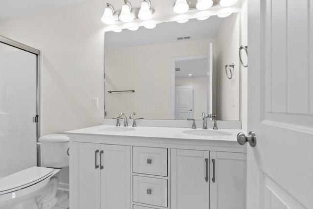 bathroom featuring tile patterned floors, dual vanity, and toilet