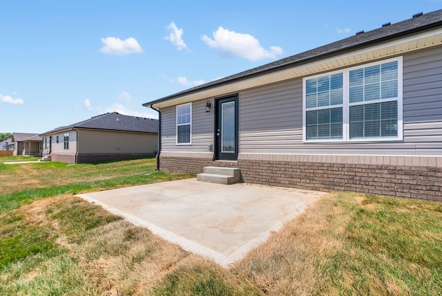 rear view of property with a lawn and a patio