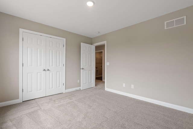 unfurnished bedroom featuring a closet and light carpet