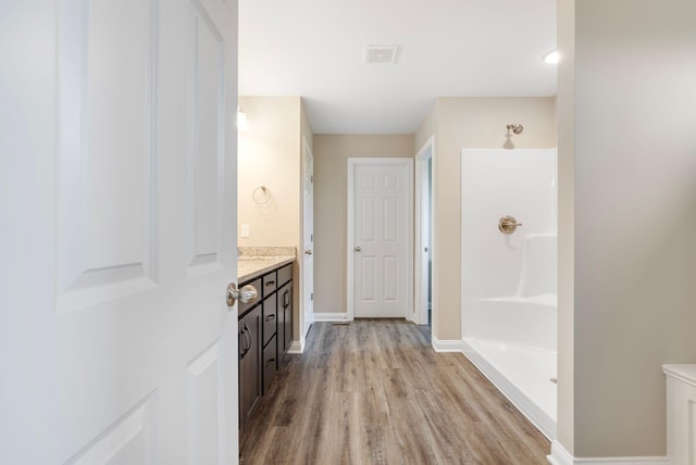 bathroom with a shower, vanity, and wood-type flooring