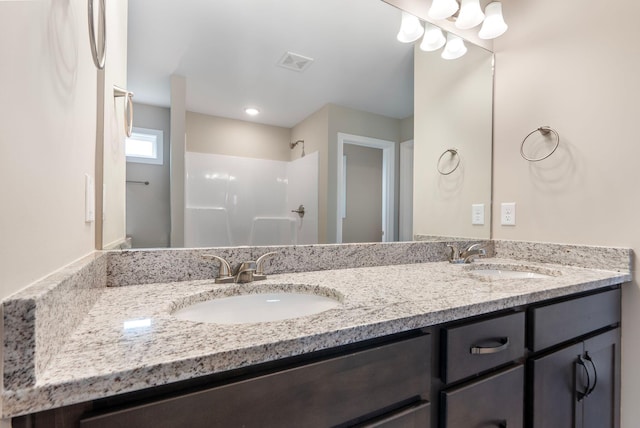 bathroom featuring walk in shower and vanity