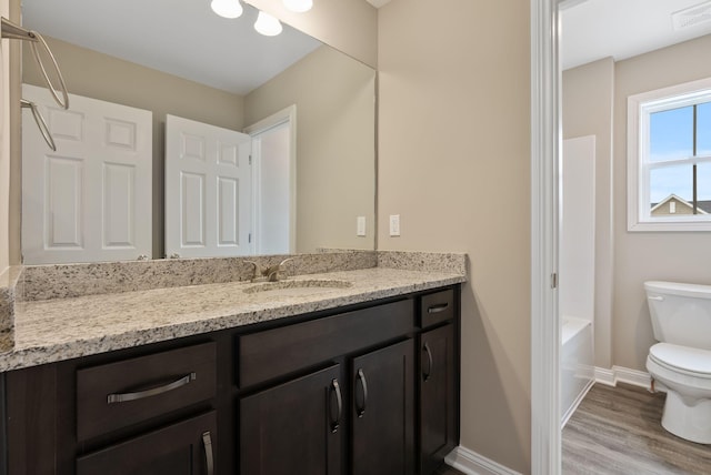 full bathroom with hardwood / wood-style flooring, shower / tub combination, vanity, and toilet