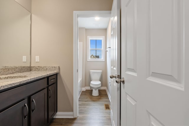 full bathroom featuring toilet, tub / shower combination, wood-type flooring, and vanity