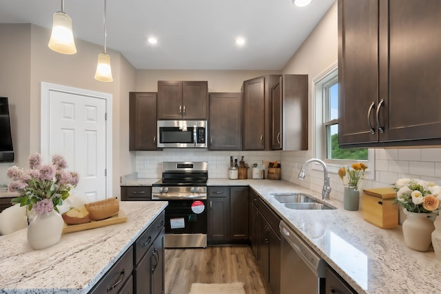 kitchen with sink, backsplash, dark brown cabinets, and appliances with stainless steel finishes