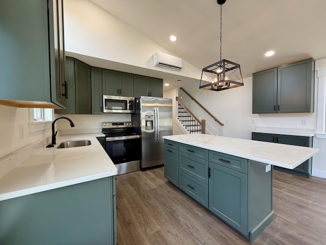 kitchen with a kitchen island, hanging light fixtures, stainless steel appliances, a sink, and a wall mounted AC