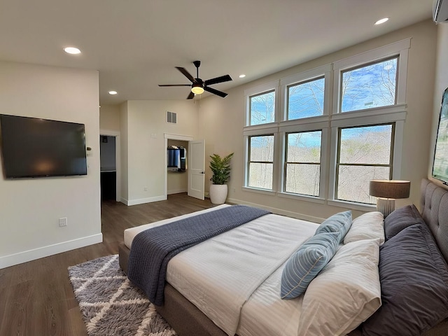 bedroom with dark wood-style flooring, visible vents, baseboards, and multiple windows