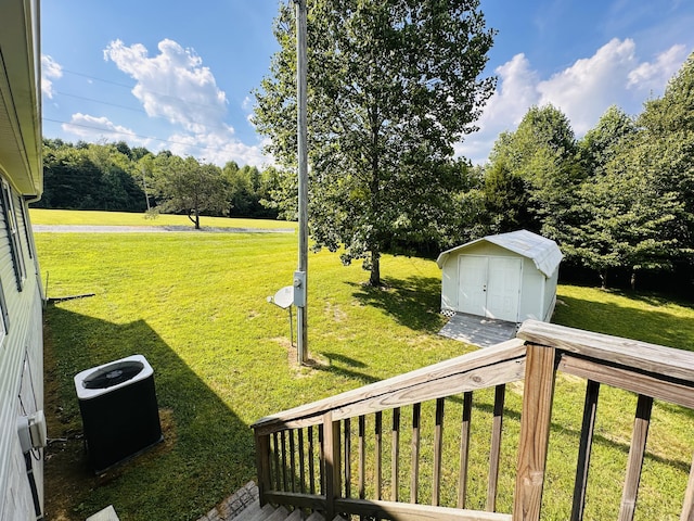 view of yard with a storage unit, a deck, and central AC