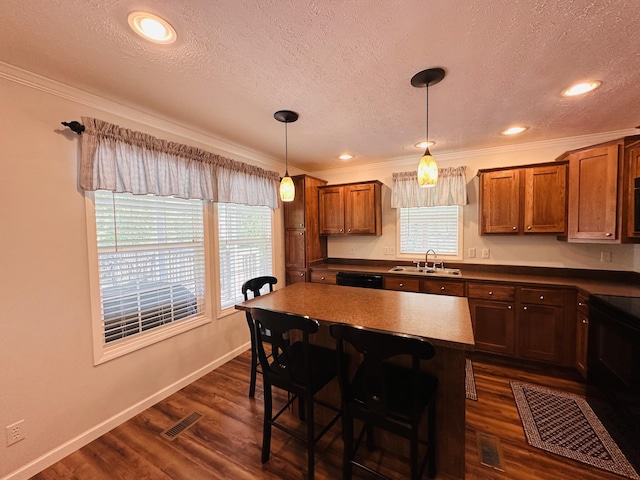 kitchen with ornamental molding, decorative light fixtures, black appliances, and sink