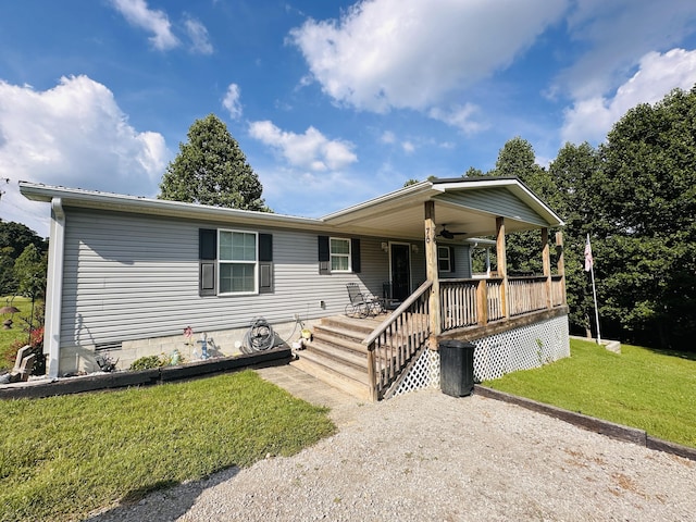 manufactured / mobile home with ceiling fan, a porch, and a front yard