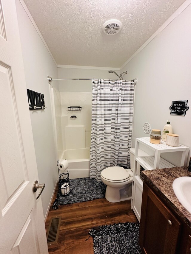 full bathroom featuring vanity, toilet, wood-type flooring, and a textured ceiling