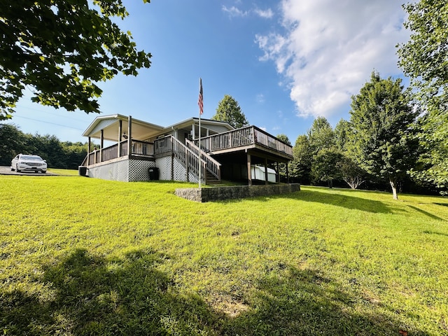 back of property with a deck and a lawn