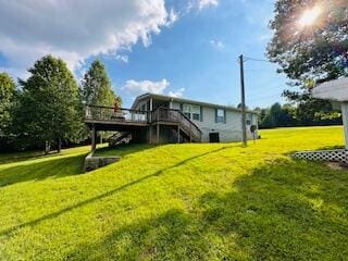 rear view of property featuring a wooden deck and a lawn