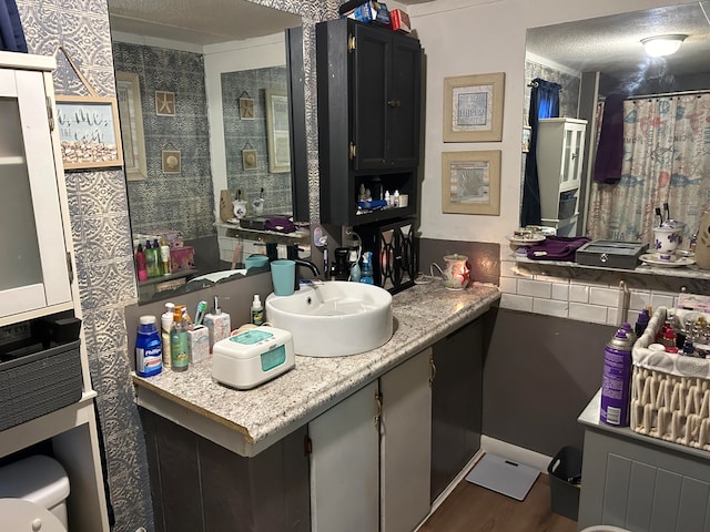 bathroom featuring hardwood / wood-style floors, vanity, a textured ceiling, and toilet