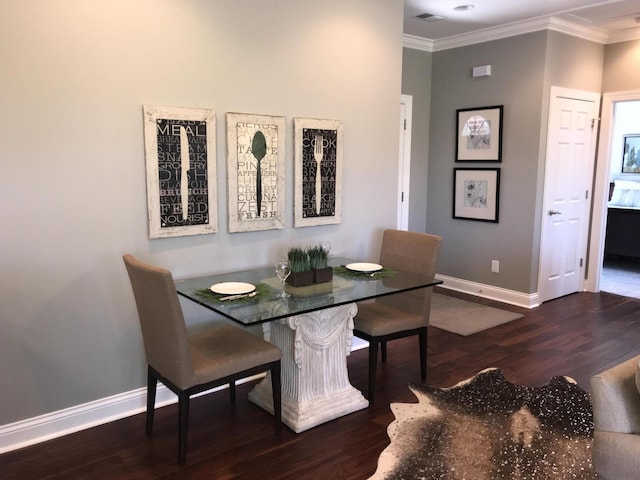 dining room with dark hardwood / wood-style flooring and crown molding