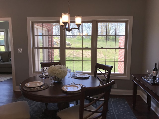 dining room with dark hardwood / wood-style flooring and a notable chandelier