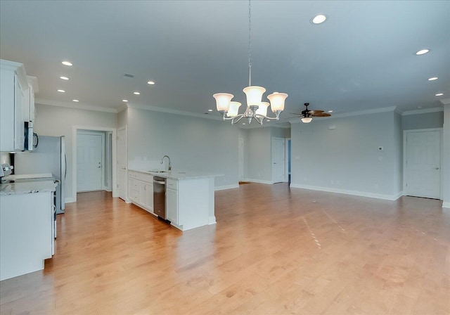 kitchen featuring pendant lighting, ceiling fan with notable chandelier, sink, stainless steel dishwasher, and white cabinetry