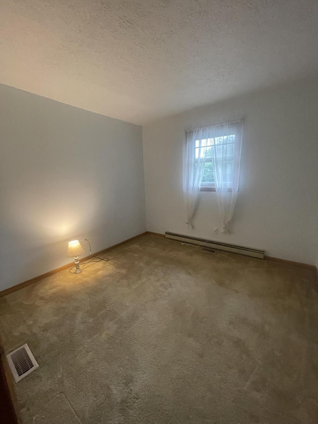 spare room featuring carpet, a textured ceiling, and baseboard heating