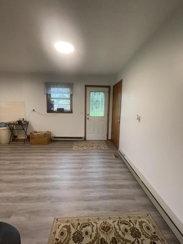 foyer entrance with light wood-type flooring and baseboard heating