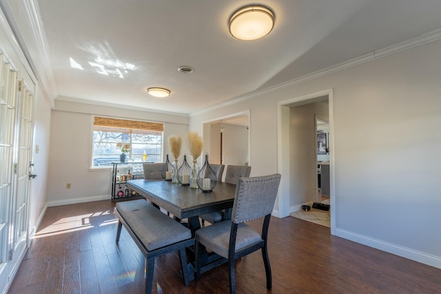 dining room with crown molding and dark hardwood / wood-style flooring