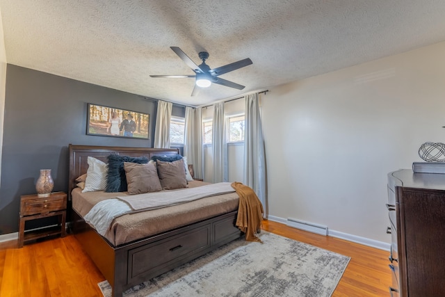 bedroom featuring ceiling fan, a textured ceiling, and light hardwood / wood-style flooring