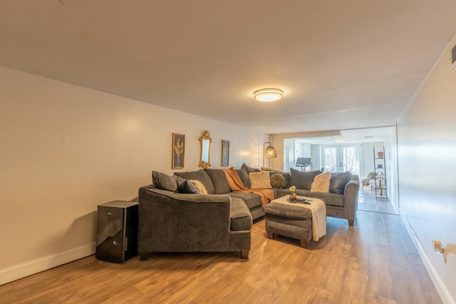 living room with french doors and light wood-type flooring