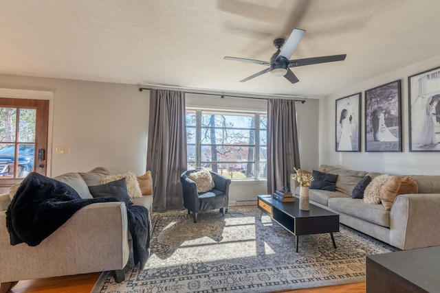 living room featuring ceiling fan, plenty of natural light, hardwood / wood-style floors, and a textured ceiling