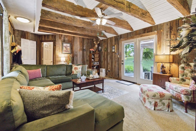 living room with wood ceiling, ceiling fan, wooden walls, beamed ceiling, and light colored carpet