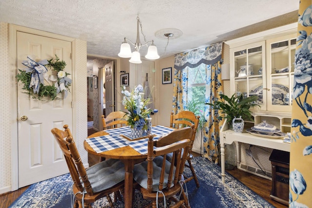 dining area with dark wood-type flooring and a textured ceiling