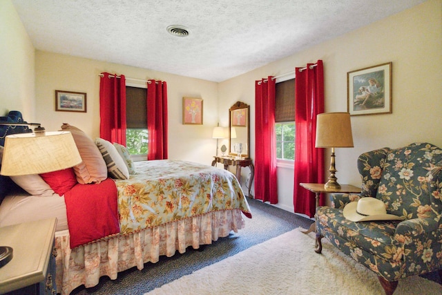 carpeted bedroom featuring a textured ceiling