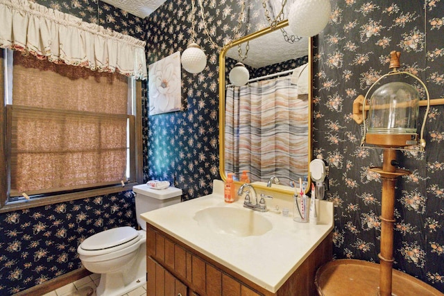 bathroom with vanity, toilet, and a textured ceiling