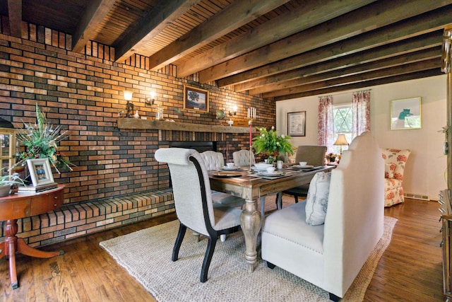 dining area with hardwood / wood-style flooring, brick wall, and beamed ceiling