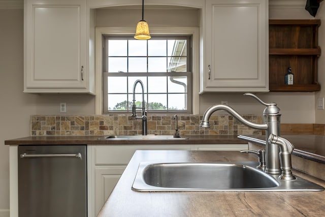 kitchen featuring stainless steel dishwasher, decorative light fixtures, sink, and white cabinets