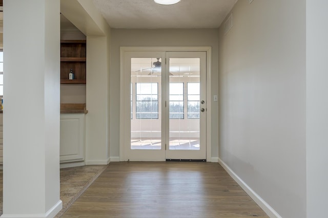 entryway with a textured ceiling and light wood-type flooring