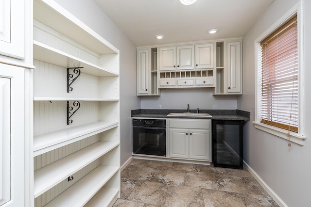 kitchen with sink, oven, and white cabinets