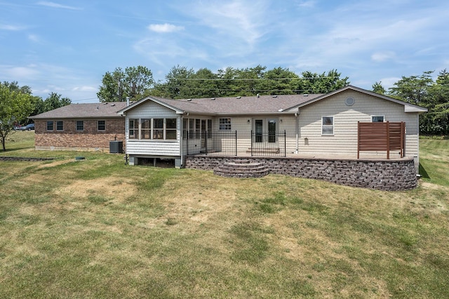 rear view of house featuring cooling unit, a lawn, a sunroom, and a patio