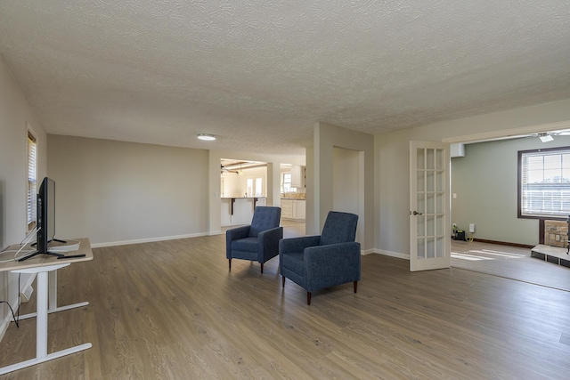 living area featuring hardwood / wood-style flooring, french doors, and a textured ceiling